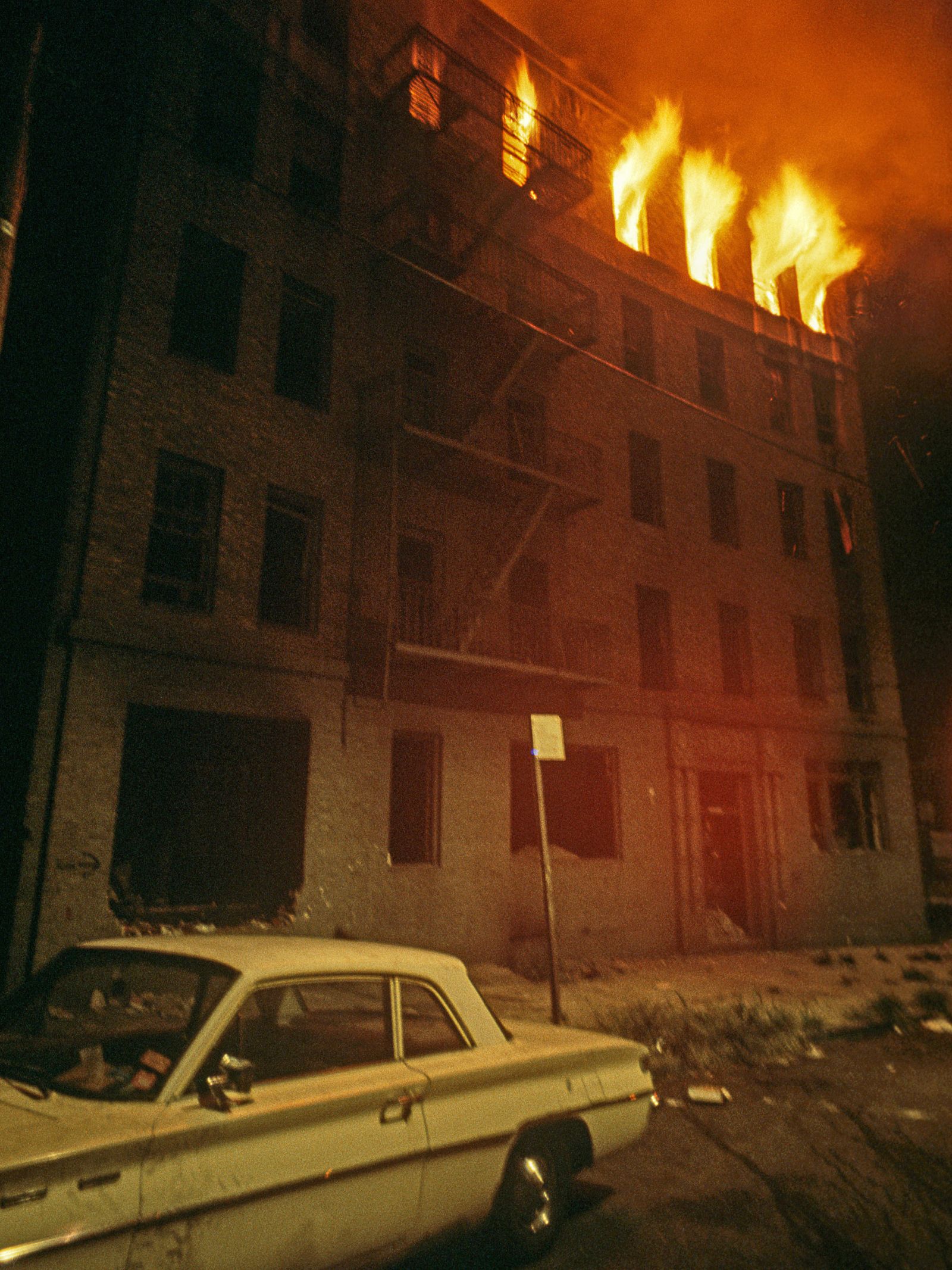 A photograph of an abandoned tenement burning in the South Bronx